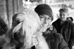 Woman with glasses holding dog and smiling