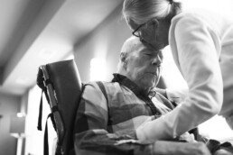 woman kissing senior man's forehead