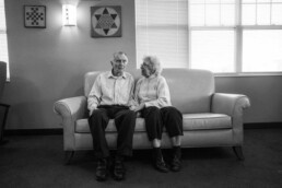 Elderly couple, man and woman sitting on couch together