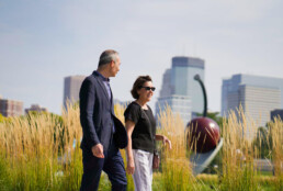 Mature man and woman walking through Minneapolis sculpture garden