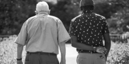 back sides of diverse male and senior man walking