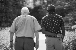 back sides of diverse male and senior man walking