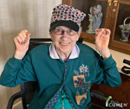 Warm Heads, Happy Faces program: senior woman at an Ecumen community wearing a knit hat and smiling.