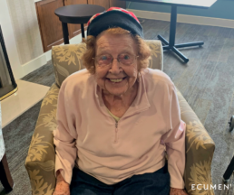 Warm Heads, Happy Faces program: senior woman at an Ecumen community wearing a knit hat and smiling.