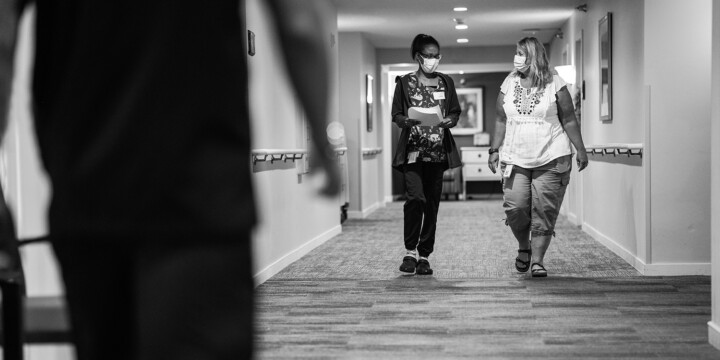 Two female Ecumen employees walking down hall