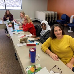 group of Ecumen team members writing Holiday cards to Ecumen residents