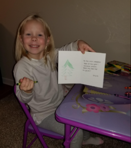 little girl coloring a Holiday card for Ecumen residents